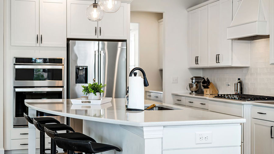 A white, modern kitchen with stainless appliances.